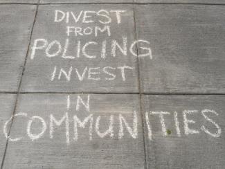 writing on sidewalk that says divest from policing invest in communities