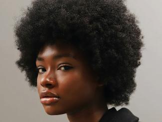 black woman with an afro is looking at the camera