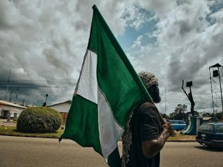 woman holding up nigerian flag
