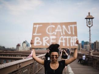 person holding a sign saying i can't breathe