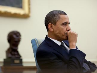 president obama holding a fist to his mouth