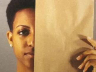 black person holding face up to brown paper bag