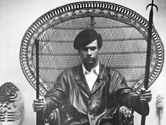 huey newton sitting in a peacock chair
