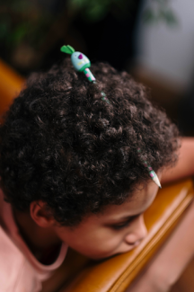 black child with a pencil in hair