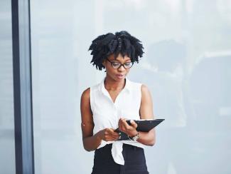 black woman in glasses with notepad