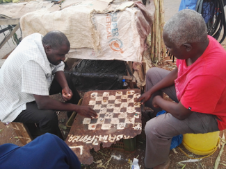 two african men playing checkers