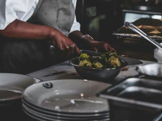 chef using knife in front of a bowl