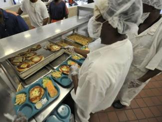 prisoners serving food in a prison cafeteria