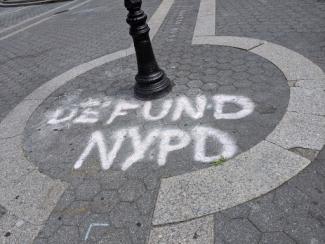 spraypaint on concrete that says defund nypd