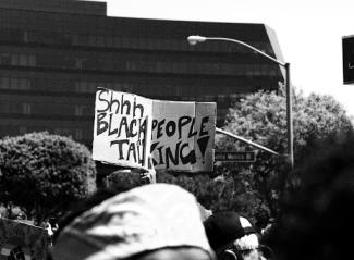 person holding up sign that says shhh black people talking