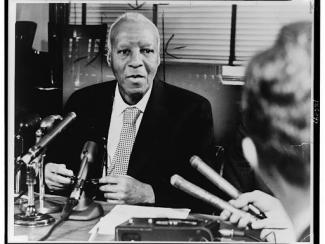 a philip randolph seated behind microphone
