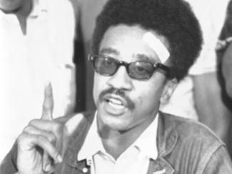 black and white photo of h rap brown speaking with an index finger raised