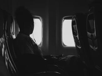 person sitting in plane next to window