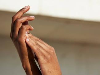 a close up of a persons hands with a building in the background
