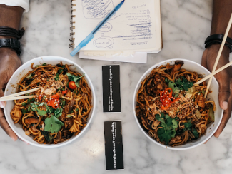 two white bowls filled with noodles on a restaurant table