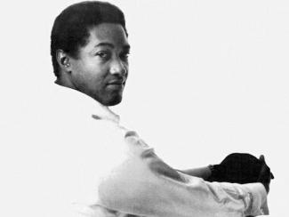 sam cooke sitting down holding his knee in a pose
