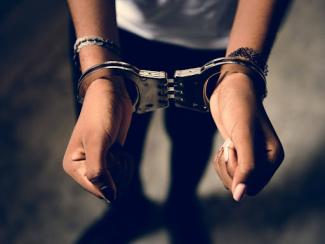 person standing up with handcuffs on wrists