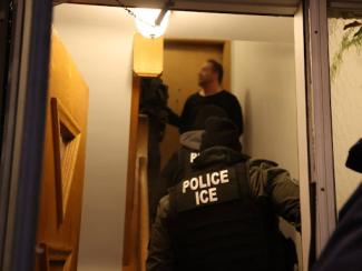 us immigration and customs enforcement agents going through a door