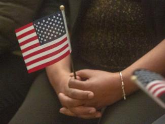 hands clasping an american flag
