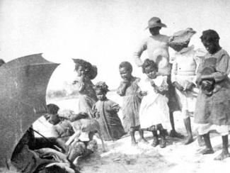 black children with dog on the beach