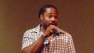 malcolm jamal warner speaking into microphone 