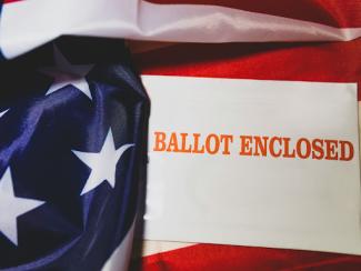 paper that says ballot enclosed with on top of an american flag