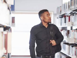 black man with a backpack in a library