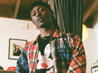 a man standing in front of a rack of clothing