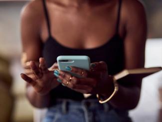 close up view of african american womans hands with smartphone 