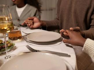 young couple holding hands while sitting down around a table