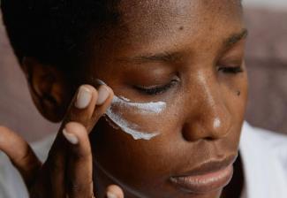 woman putting white paint on face