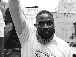 black man protestor with arm raised 