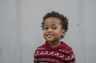 a young black child wearing a red and white sweater