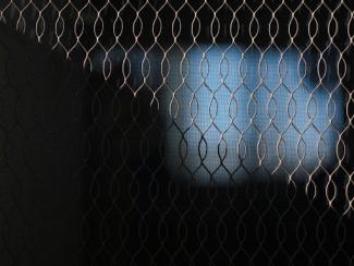 blurry image of a television screen behind a mesh fence