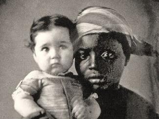black woman holding up white baby