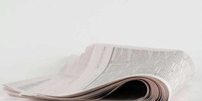 a stack of newspapers sitting on top of a white table