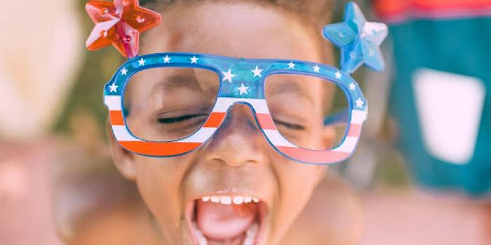 boy wearing american flag print eyeglasses sticking his mouth open