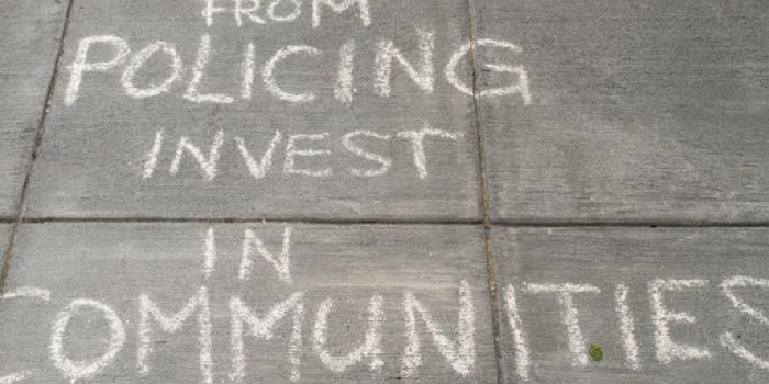 writing on sidewalk that says divest from policing invest in communities