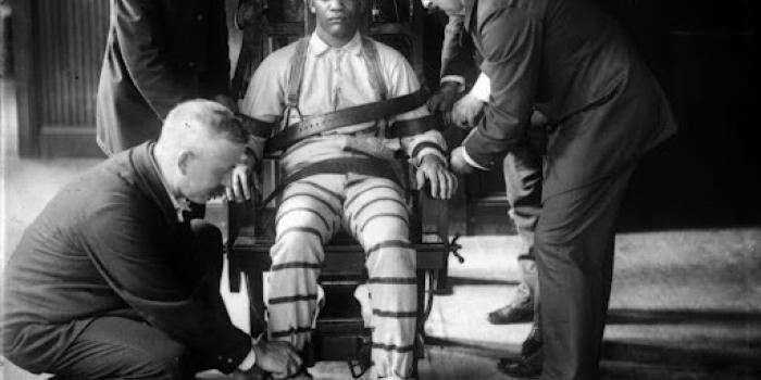 man sitting in a chair strapped