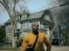 man in yellow crew neck long sleeve shirt standing near building in the daytime