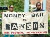 two black people holding a sign that says money bail is ransom