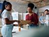 two black women showing each other what's on a ballot