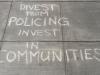 writing on sidewalk that says divest from policing invest in communities